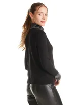Polera de tejido soft color negro, con cuello alto y puños decorados con apliques de strass. Presenta un diseño de manga larga y corte ajustado.