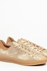 Zapatilla de cuero vacuno color rojo, con cordones al tono y suela de caucho color caramelo. Detalle de cuero vacuno color tostado en el talón.