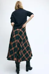 Falda midi de tiro medio, evasé, confeccionada con mezcla de viscosa y diseño de cuadros en tonos verdes, marrones y negros. Cuenta con cierre de cremallera oculta en la costura.
