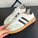 Championes deportivos de mujer, color blanco, con tres franjas laterales negras y talón negro. Suela de goma color caramelo.