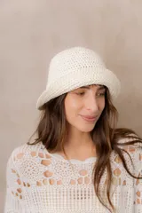 Gorro tipo bucket tejido a crochet de trama abierta, color natural, con ala corta y flexible.