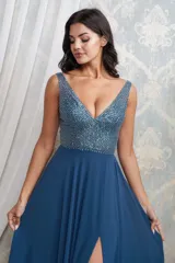 Vestido largo de fiesta color azul petróleo, con cuerpo superior bordado en pedrería y escote en V. Presenta una falda fluida de gasa con una abertura lateral profunda.