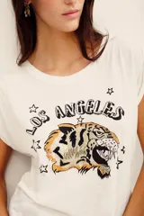 Remera blanca de algodón con cuello redondo, mangas cortas con vuelta y estampa frontal de un tigre con la inscripción 'Los Angeles' y estrellas.