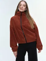 Campera de tela fleece doble, color negro, con cierre frontal completo, cuello alto y bolsillos laterales. Presenta puños y bajo elastizados para un ajuste cómodo.