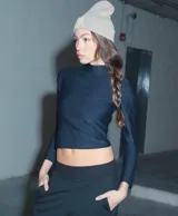 Polera de manga larga y cuello alto, confeccionada en lycra mate de color negro, con diseño ajustado al cuerpo.