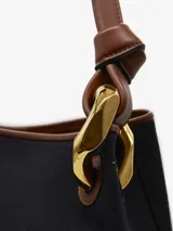 Bolso de hombro tipo bucket color crema, con detalles en cuero negro y herrajes dorados.