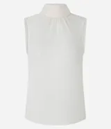 Blusa color crema sin mangas de crepé con cuello alto y lazo por tiras largas de tejido. La prenda tiene cierre por gota con detalle de perla artificial atrás del cuello y frunzidos en la parte delantera.