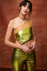 Top asimétrico de un solo hombro, con diseño diagonal que combina cuero sintético color camel en la parte superior y cuero sintético metalizado verde lima en la parte inferior, unidos por costuras en zigzag.