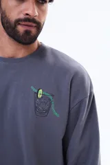 Buzo de felpa gris con cuello redondo y corte oversize. Presenta una estampa gráfica en la espalda que ilustra un vaso con una rodaja de lima y texto en colores verde y blanco.