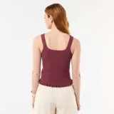 Musculosa acanalada de punto color bordó, con escote cuadrado y cartera de botones frontal decorativa con terminación de volados en el ruedo.