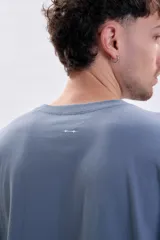 Remera de manga larga en color azul piedra, con corte holgado y cuello redondo. Presenta una pequeña estampa minimalista en el pecho con el texto 'MODERN ease'.