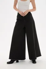 Pantalon de jean azul de corte ancho y tiro alto, con ruedo deshilachado.