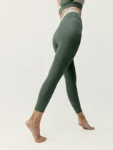 Calza deportiva verde con cintura alta en color beige.