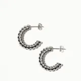 Par de caravanas plateadas tipo argolla con diseño de esferas.