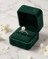 Anillo de plata 925 con diseño abierto, presenta una perla central y un detalle de corazón con circonias incrustadas.