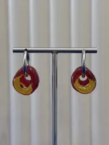 Aros tipo argolla de plata 925 con dijes circulares de vidrio en colores rojo y ámbar.