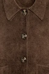 Chaqueta de punto color marrón con cuello solapa, manga larga y cierre frontal con botones. Presenta dos bolsillos de plastrón en el delantero y un diseño de corte recto.