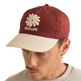 Gorro de gabardina color borgoña con visera beige, logo de flor bordado en blanco y texto "Rhythm" bordado en blanco.