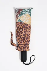 Paraguas plegable Bimba Y Lola con funda estampada combinada de animal print y motivos florales, mango negro con logo en relieve y tira de muñeca.