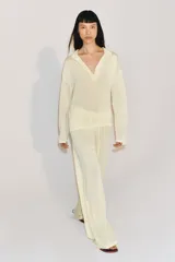 Pantalón de corte recto y tiro medio, confeccionado en tejido fluido de lyocell. Presenta cintura elástica con cordón ajustable.