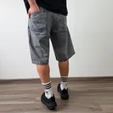 Bermuda de jean corte baggy en color gris oscuro con efecto deslavado, diseño amplio y bolsillos laterales.