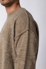 Sweater de punto grueso en color verde oliva, con diseño oversized, cuello redondo y mangas largas con puños acanalados.