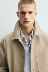Sobrecamisa relaxed fit color beige confeccionada en tejido de algodón con estructura canvas, cuello solapa, manga larga con trabilla en los puños, bolsillos frontales de plastrón y cierre de botonadura.