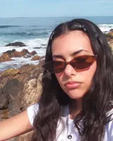 Anteojos de sol ovalados color marrón con marco de acetato y lentes marrones.