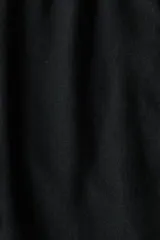 Pantalón negro de corte relajado, confeccionado en mezcla de lino y viscosa, con cintura elástica con cordón de ajuste y bolsillos laterales.