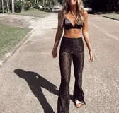 Pantalón de encaje negro con corte acampanado y cintura elástica.