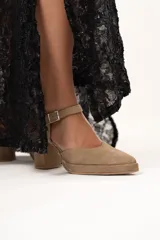 Sandalias de tacón color visón con puntera triangular y tira con hebilla al tobillo.