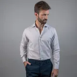 Camisa negra de algodón con cuello clásico, manga larga y cierre frontal con botones. Presenta un logo bordado en el pecho. Corte entallado.