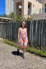 Vestido corto sin mangas con estampado abstracto en tonos naranja y celeste.