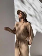 Buzo de tejido waffle color beige, con cuello redondo, mangas largas con puños y corte cropped.