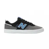 Championes urbanos New Balance modelo 306, con diseño de perfil bajo en combinación de colores negro, gris y detalles en celeste. Confeccionados en gamuza y material sintético, cuentan con el logo N lateral y suela de goma blanca.