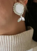 Aros plateados con forma circular y colgante con forma de gota.