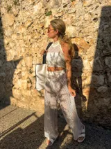 Top blanco tejido calado con cuello halter y corte crop.