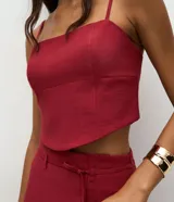 Blusa de sastrería color bordó, con escote recto, breteles finos ajustables y diseño estructurado con recortes que moldean el busto. Cuenta con cierre de cremallera en la espalda.