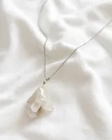Collar con cadena plateada y dije de cuarzo blanco irregular.