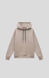 Hoodie oversize de color beige, confeccionado en frisa premium. Presenta capucha ajustable con cordones, bolsillo tipo canguro frontal y puños con aberturas para pulgares.