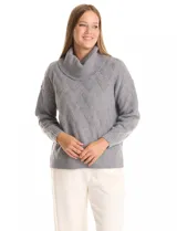 Buzo de punto grueso con textura en relieve, de cuello volcado y mangas largas con hombros caídos. Presenta puños y ruedo con terminación en rib.