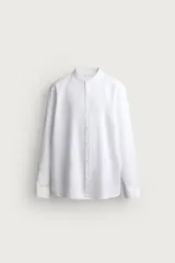 Camisa de corte relajado, confeccionada en mezcla de lino y algodón. Presenta cuello tipo mao, manga larga con puño abotonado y cierre frontal con botones.