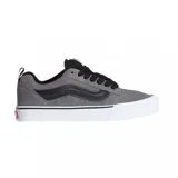Championes Vans modelo Knu Skool, de diseño retro con estética chunky. Confeccionados en gamuza gris con detalles en negro, presentan la icónica banda lateral acolchada y una suela de goma blanca con plataforma.