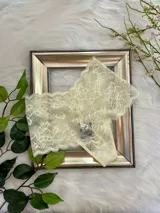 Bombacha hipster color champagne de encaje floral con cintura elástica y refuerzo de algodón.