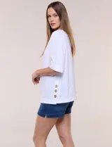 Blusa de algodón blanca, de manga corta amplia, con tajo en el ruedo lateral decorado con tres botones.