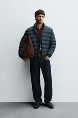 Cazadora acolchada de corte regular fit, confeccionada en tejido técnico repelente al agua. Presenta cuello subido, cierre frontal de cremallera, bolsillos laterales de vivo y puños con elástico.