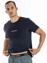 Conjunto de pijama Calvin Klein Modern Structure, compuesto por una remera azul marino de manga corta con logo estampado en el pecho y un short a rayas horizontales en tonos azul y gris con cintura elástica.