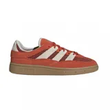 Championes Adidas modelo Handball Spezial en color naranja, confeccionados en gamuza y malla, con las icónicas tres tiras en color crema y suela de goma color caramelo.