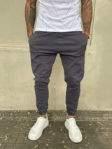 Pantalón babucha gris de gabardina con cintura elástica y puños ajustados.