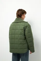 Campera marrón capitoneada de manga larga con cuello alto de tela, cierre frontal y bolsillos laterales con cierre.